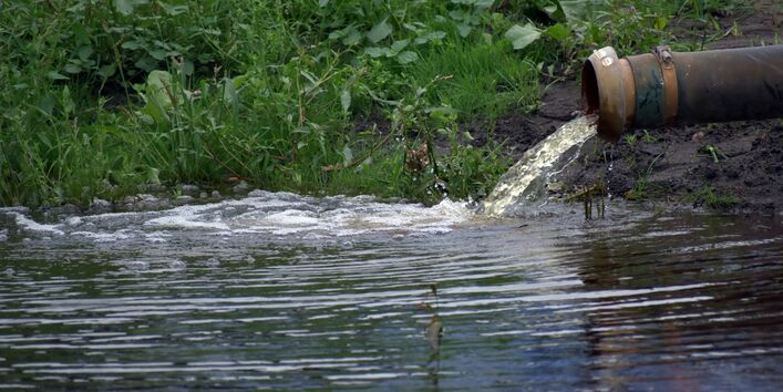 Foto von einem Rohr, welches verunreinigtes Wasser in einen Bach leitet