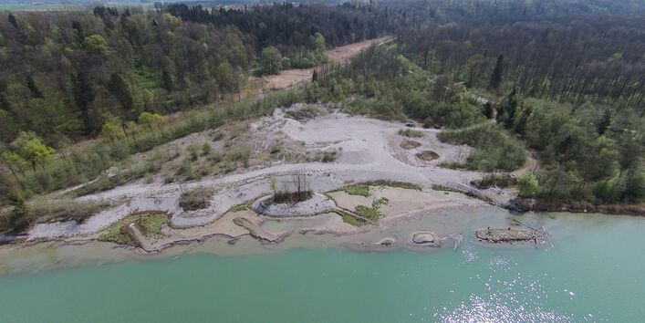 Luftbild des Laimbacher Kiesdepots am Inn. Einseitig entlang des Innufers liegen ausgedehnte Kiesbänke, die teilweise kleine Inseln bilden. Die Kiesbänke sind noch frei von Vegetation.