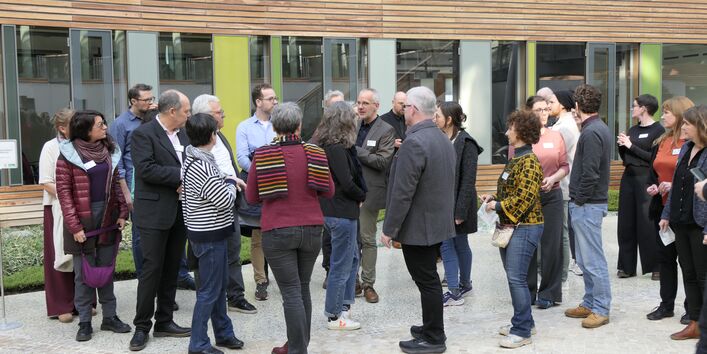 Eine Gruppe von Menschen steht im Atrium des UBA.