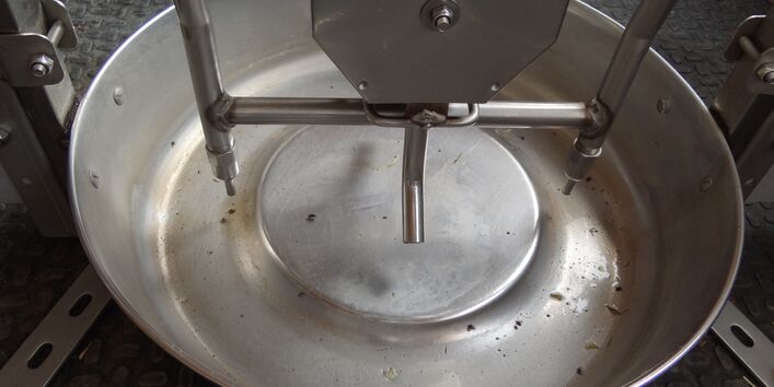 Foto eines runden Edelstahltrogs, bei dem das Wasser nicht vollständig ablaufen kann.