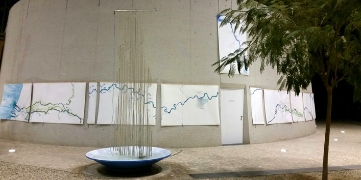 Kunstinstallation im Vorraum des UBA Dessau: über einer großen Schale hängt ein Vorhang aus Schnüren, an dem Wasser herunterläuft, man erkennt die Silhouette eines Menschen