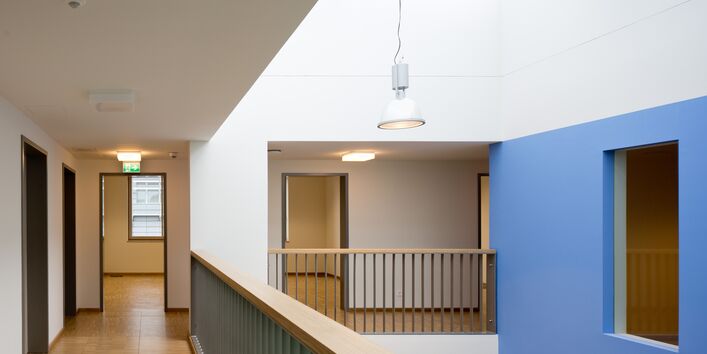 Flure mit Holzfußböden auf einer Galerie, weiße und blaue Wandflächen