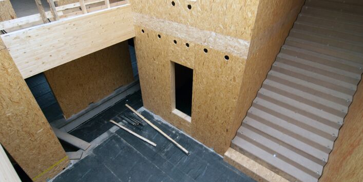 Treppenhaus, die Innenwände aus noch rohen Holzwerkstoffplatten