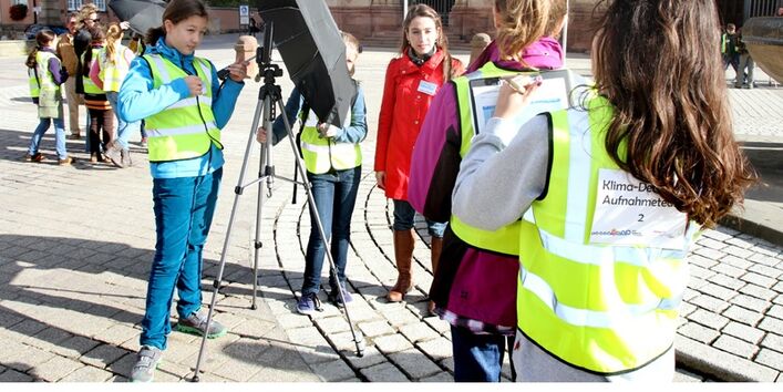 Schülerinnen mit Messgeräten in der Stadt. 