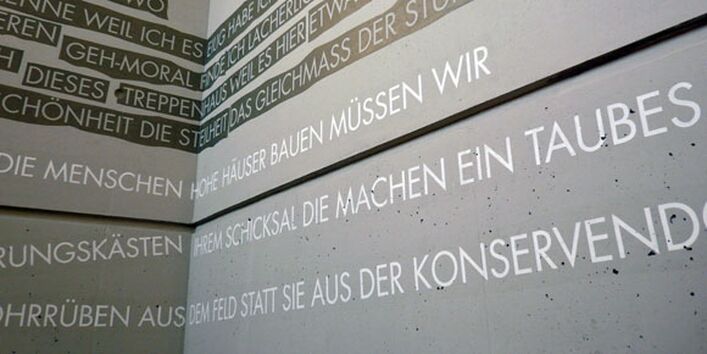 Eine Betonwand beschrieben bzw. bemalt mit kritischen Texten & Worten