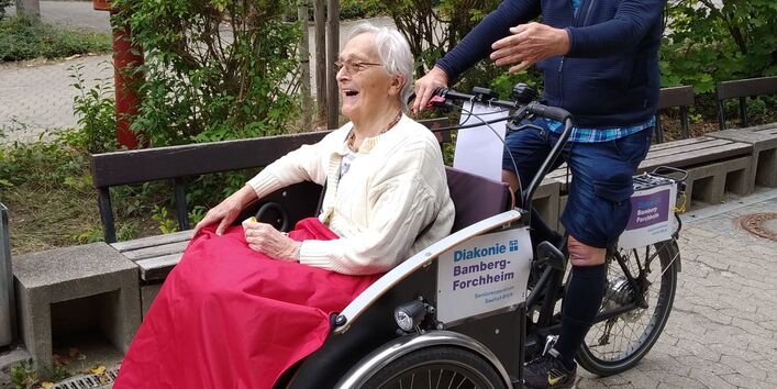 Seniorin lässt sich in Rikscha fahren