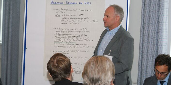 Teilnehmer steht vor Moderationswand und trägt vor.