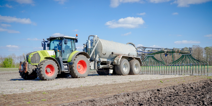 Ackerfläche mit Traktor und Schleppschlauchapplikator.