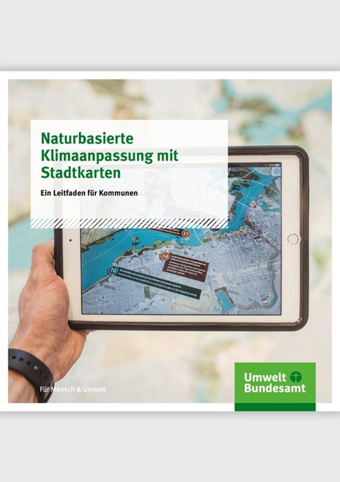 Hand hält ein Tablet mit einer digitalen Stadtkarte