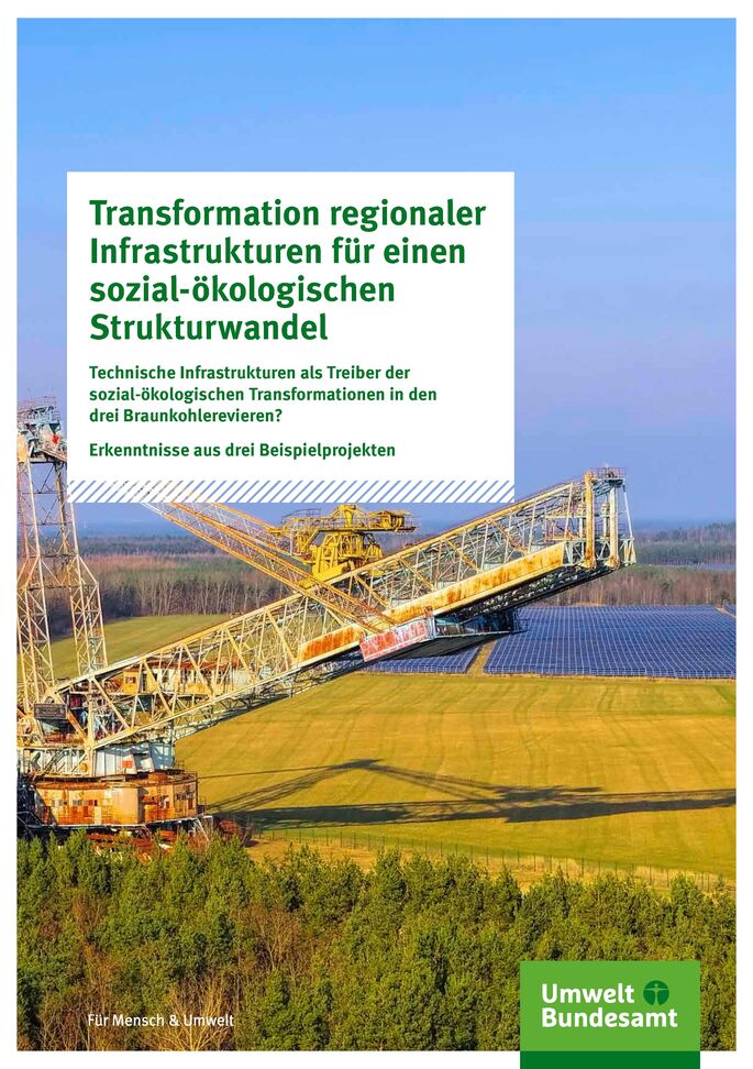 Großer Braunkohlebagger zwischen Wald und Wiese. Im Hintergrund ein Solarfeld.