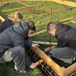 Das Bild zeigt einen Teil der Projektgruppe beim Bau der Schalung und Bewehrung für das Betonfundament.