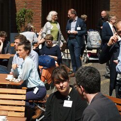 Menschen sitzen draußen beisammen und unterhalten sich