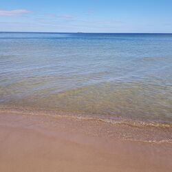 Leerer Sandstrand, kleine Wellen.