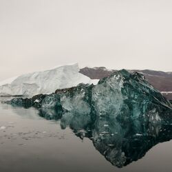 schwarz gefärbter Eisberg im Wasser 