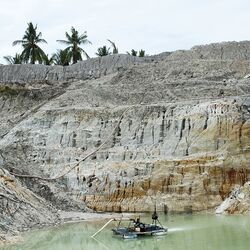 Zinnabbau. Felswand und kleiner Wassertümpel.