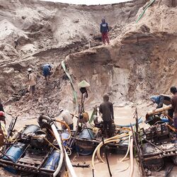 Mehrere Männer mit Werkzeugen beim Zinnabbau.