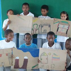 Kinder halten ihre Zeichnungen in die Kamera und strahlen