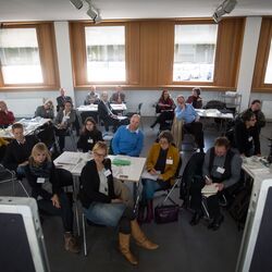 Teilnehmer sitzen an Arbeitsgruppentischen