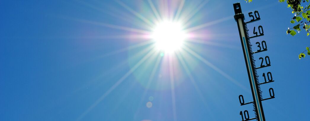 Bei starker Sonnenstrahlung sind auf einem Thermometer hohe Temperaturen zu erkennen.