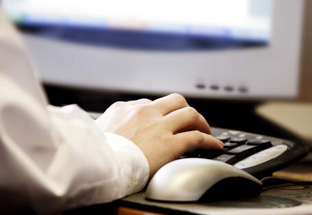 Anschnitt eines Monitors, Nutzung von Tastatur und Maus durch Person