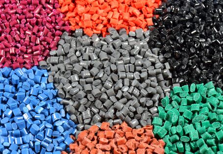 in Waben angeordnete Haufen verschiedenfarbiger Kunststoffgranulate