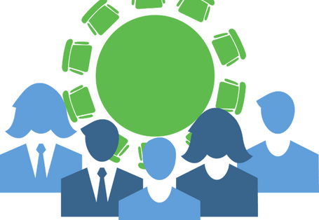 Eine Gruppe Menschen sitzt um einen runden Tisch.