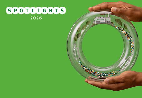 Hände halten Ring aus Glas, im Glas wird Recycling Prozess dargestellt