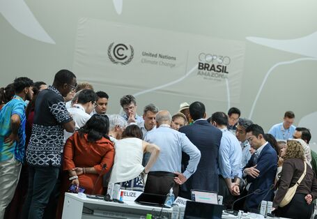 Delegates from various countries are putting their heads together to discuss in a huddle at COP30 in Brazil.