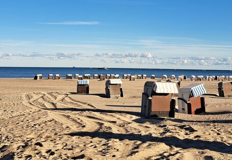 Auf dem Bild ist der Strand mit Strandkörben an der Ostsee dargestellt. 