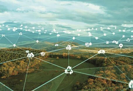 The image is directed towards the sky against the sun and shows a circle of ten stretched hands in a circle.