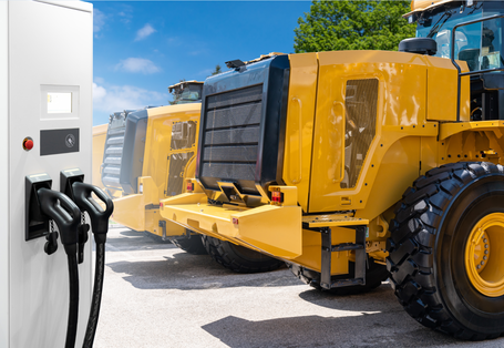 Elektrischer Radlader auf einer Baustelle mit Ladeeinrichtung.