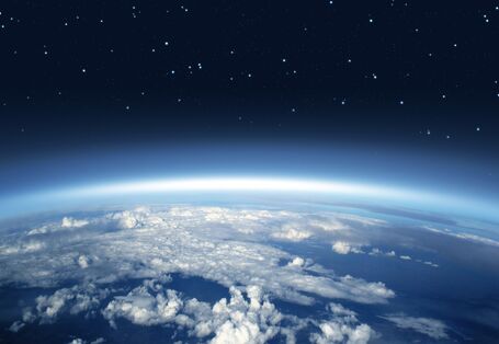Photo showing the atmosphere high above the Earth, with clouds below and stars above