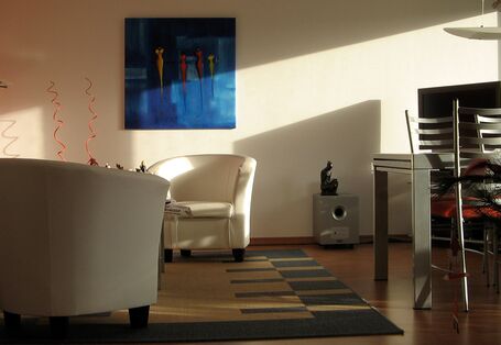 Wohnzimmer mit Sesseln, Teppich, Bilder, Esstisch