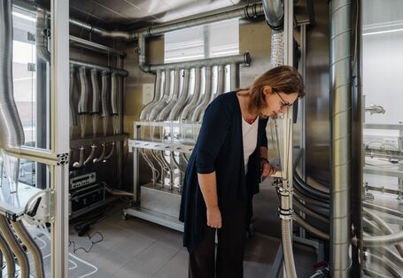 Eine Frau riecht im Labor an einem Trichter, um den Geruch eines Produktes zu bewerten.