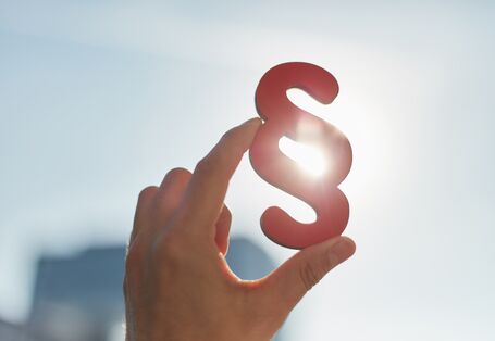 Hand mit Paragrafenzeichen