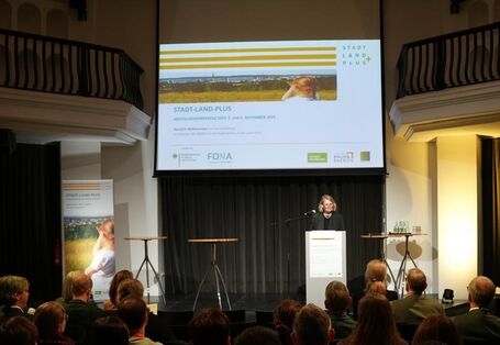 BMBF-Staatssekretärin Judith Pirscher spricht auf der Konferenz "Aus Stadt und Land wird Plus".