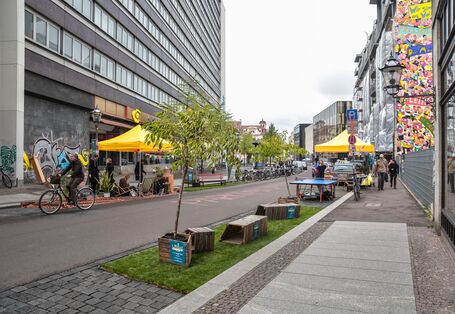 Randstreifen einer Straße ist von Sitzgruppen belegt
