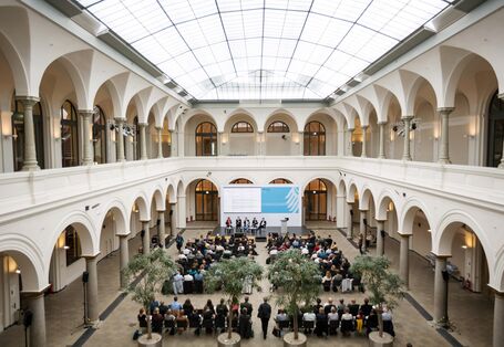 200 Teilnehmende sitzen im Atrium 