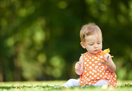 Ein Kleinkind auf einer Wiese.
