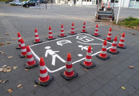 Leitkegel schützen das frisch gemalte Verkehrszeichen