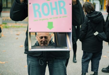 Spiegelung einer Person, die durch das umgedrehte Persikop sieht.