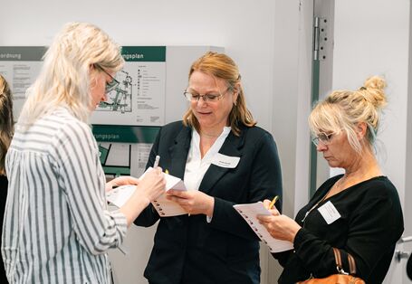 3 Teilnehmerinnen stehen beisammen und unterhalten sich angeregt