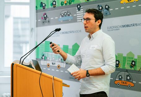 Günter Rasch steht an einem Stehpult und präsentiert