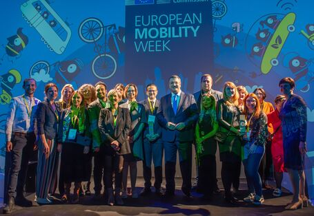 Vertreterinnen der Finalisten- und Gewinnerkommunen sowie Organisationen stehen beisammen und in ihrer Mitte EU-Kommissar Tzitzikostas und Generaldirektorin Kopczynska 