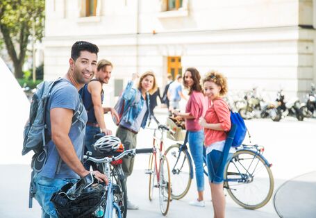 Menschen stehen mit ihren Fahrrädern in der Stadt