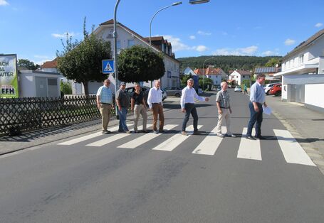 Bürgerinnen und Bürger gehen über den Zebrastreifen, wie die Beatles auf dem Abbey-Road Cover