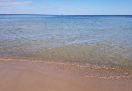 Leerer Sandstrand, kleine Wellen.