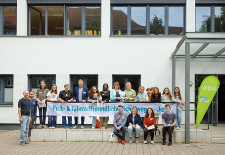 Gruppenfoto mit Banner „Fuß- & fahrradfreundliche Schulwege – jetzt!“