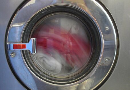 Blick auf die Trommel einer Waschmaschine, in der gerade Wäsche rotiert