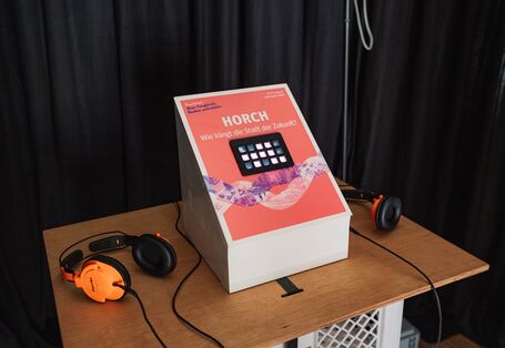 Über Knöpfe können Klänge zusammengestellt werden. Zwei Kopfhörer liegen bereit. 